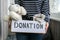 Female volunteer holding donation box with old used toys and clothes indoors. Happy Charity. Unrecognizable woman