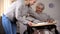 Female volunteer serving dinner to handicapped old woman, elder care, help