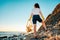 A female volunteer stands with a plastic bag in her hand. Back view. Cleaning of the coastal zone and wild beaches. The