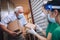 Female volunteers in mask gives an elderly man boxes with food near his house. Quarantined, . Coronavirus covid-19.