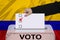 Female voter drops a ballot in a transparent ballot box against the backdrop of the Colombia national flag, concept of state