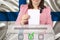 Female voter lowers the ballot in a transparent ballot box against the background of the national flag of Finland, concept of