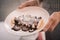 Female waitress holding white plate with pancakes topped with chocolate