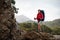 Female wanderer poses on top of a rock