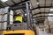 Female warehouse worker driving forklift. Warehouse worker preparing products for shipmennt, delivery, checking stock in