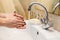 Female washing hands thoroughly with soap in hot water, close up view