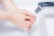 Female Washing Soaped Hands Under Turned On Water In Bathroom