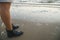 Female in waterproof leather boots on sea sand