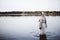 Female wearing a biblical gown and standing in the water while smiling in the distance