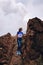 Female wearing a hat standing on huge volcanic rock next to the volcano crater at masaya volcano national park