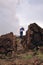 Female wearing a hat standing on huge volcanic rock next to the volcano crater at masaya volcano national park