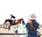 Female wearing hat watching horse jumping event