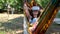 Female wearing virtual reality glasses rests in a hammock near a tree, imagining a dream come true, an invented world