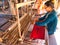 A female weaver producing silk fabric on a traditional hand loom on Silk Island / Koh Dach near Phnom Penh, Cambodia