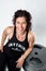 Female Weight Trainer Leaning on a Pile of Weight Plates