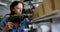 Female welder using drill machine on wooden plank 4k