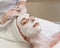 Female with white facial mask in spa treatment alternative medicine side view