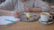 female white shirt working cafe while having lunch desert tea eating cake wooden