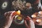 Female wiccan witch wearing vintage jewelry holding yellow candle and pouring wax into a red white gold colored vintage teacup