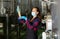 Female winemaker in protective mask analyze the white wine in beaker