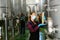 Female winemaker in protective mask analyze the white wine in beaker