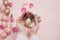 Female, woman hands holding an Easter egg. Pink and Gold Easter Eggs. Pastel Easter Concept with Eggs, Flowers and Feathers