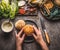 Female women hands making homemade tasty burger with chicken on rustic kitchen table background with ingredients