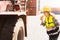 Female worker eating bread snacks while working driving a forklift container.