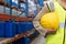 Female worker holding hard hat in warhouse