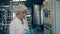 Female worker is operating a control panel in a factory unit