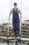 Female worker in oyster farm collecting cages with oysters