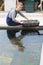 Female worker with oysters in containers at oyster farm