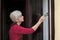 Female worker paint wooden window to brown color, old house window renovation