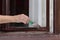 Female worker paint wooden window to brown color, old house window renovation, closeup of hand with tool