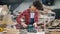 Female worker polishing wood with belt sander working in timber workshop