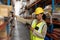 Female worker scanning package with barcode scanner while using digital tablet in warehouse