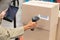 Female worker scanning package with barcode scanner while using digital tablet in warehouse