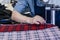 Female worker on a sewing manufacture uses electric cutting fabric machine. Textile industry, clothing production, fabric cutting