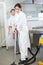 Female worker vacuuming flooring in kitchen