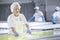 Female worker on white feta cheese production line in an industrial factory