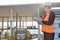 Female worker writing on clipboard while looking at trucks entering in shipping yard