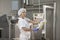 Female worker on yellow cheese production line in an industrial