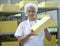 Female worker on yellow cheese production line in an industrial