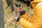 Female in yellow jacket with golden plastic thermo cup outdoors in autumn.