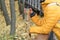 Female in yellow jacket  holding golden plastic thermo cup outdoors in autumn