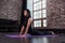 Female yoga beginner doing bhujangasana cobra pose on mat in loft apartment