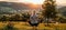 Female yoga practitioner in tree pose at sunset in serene and picturesque open field setting