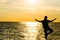 Female yoga vriksasana silhouette on beautiful beach during sunset.