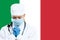 Female young doctor with stethoscope and face mask praying for God with Italy national flag on background