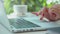 Female young hands with neat red manicure print on the laptop keyboard